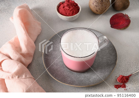Beetroot latte or pink moon milk latte in glass cup on gray background. Great warming drink. 95116400