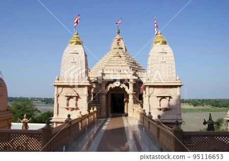 Carved temples at Nilkanthdham, an extensive religious complex with pagodas, fountains, statues & carved idols and gates, located at Poicha, Gujarat, India 95116653