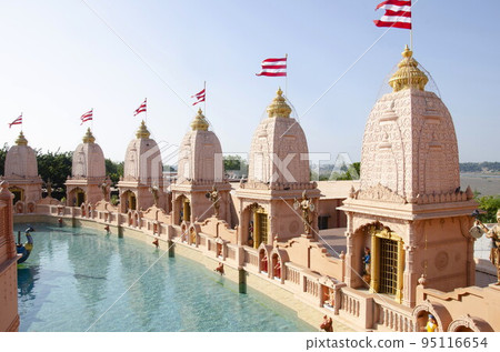 Carved temples at Nilkanthdham, an extensive religious complex with pagodas, fountains, statues & carved idols and gates, located at Poicha, Gujarat, India 95116654