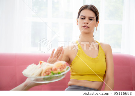 Hands serving food and young caucasian woman making sign say no food unhealthy with obese. Hands serving food and young caucasian woman making sign say no food unhealthy with obese. 95116698