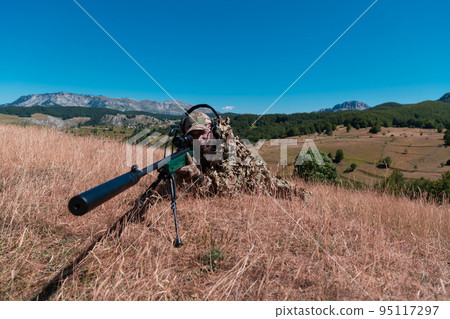 army soldier holding sniper rifle with scope and aiming in forest. war, army, technology and people concept army soldier holding sniper rifle with scope and aiming in forest. war, army, technology and people concept 95117297