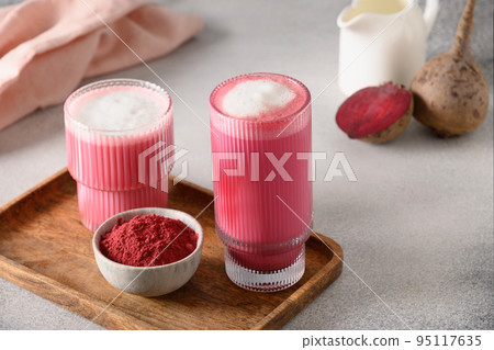 Beetroot latte or pink moon milk latte in glass cup on gray background. Great warming drink. 95117635