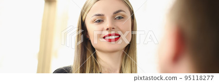 Beautiful woman hairdresser smiles at a guy, close-up 95118277