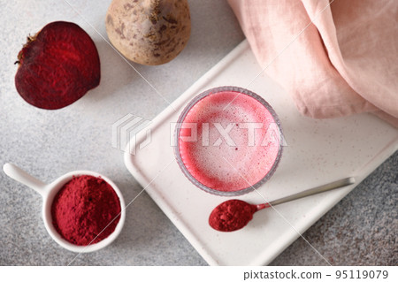 Beetroot latte or pink moon milk latte in glass cup on gray background. Great warming drink. Beetroot latte or pink moon milk latte in glass cup on gray background. Great warming drink. 95119079