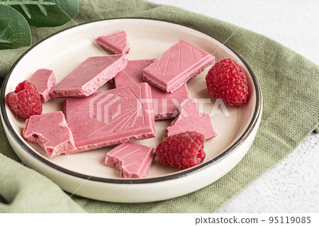 Pink or ruby chocolate, trendy dessert on a white plate with raspberries 95119085