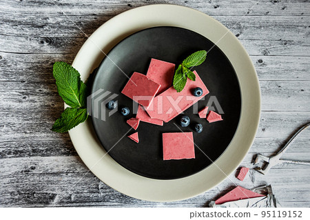 Pink or ruby chocolate, trendy dessert on a black plate on wooden grey backround Pink or ruby chocolate, trendy dessert on a black plate on wooden grey backround 95119152