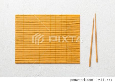 Two chopsticks and bamboo mat on cement background. Top view, copy space 95119555