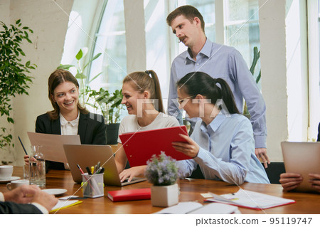 Group of mixed ages people talking, working with colleagues, co-workers at loft style office. Business, urban lifestyle, work, finance, tech concept. 95119747