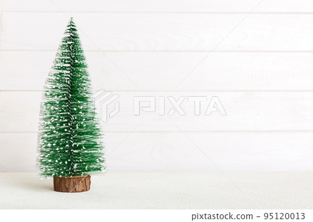 One small Christmas tree on colored background. new year decoration with copy space One small Christmas tree on colored background. new year decoration with copy space 95120013