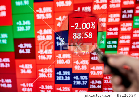 A trader looking at a stock heatmap through a magnifying glass 95120557