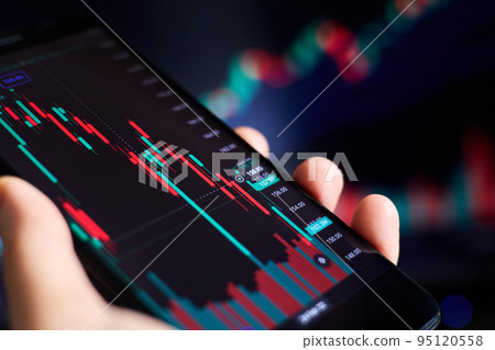 Trader analyzes stock market data in smartphone 95120558