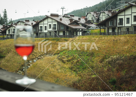 Glass of wine on wooden balcony in ski resort 95121467