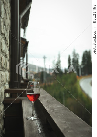 Glass of wine on wooden balcony in ski resort 95121468