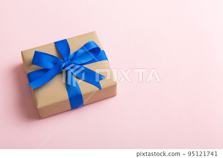 Wrapped christmas or other holiday handmade present in craft paper with colored ribbon. Present box, decoration of gift on table, top view with copy space Wrapped christmas or other holiday handmade present in craft paper with colored ribbon. Present box, decoration of gift on table, top view with copy space 95121741