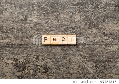 feel word written on wood block. feel text on table, concept 95121847