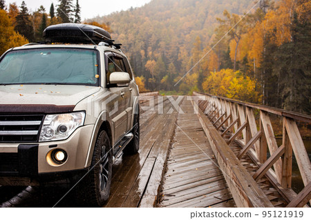4x4 car on wooden bridge in the forest in autumn 4x4 car on wooden bridge in the forest in autumn 95121919