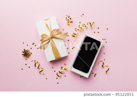Opened gift box with gold ribbon and smartphone on color background, top view. Blank open box packaging mockup , Template for your design - branding mockup 95122051