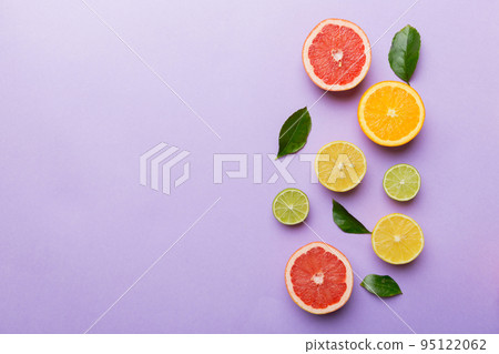 Fruit background. Colorful fresh fruits on colored table. Orange, lemon, grapefruit Space for text healthy concept. Flat lay, top view, copy space 95122062