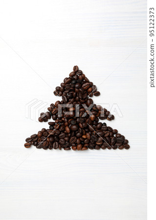 Christmas tree made of coffee beans on white wooden background Christmas tree made of coffee beans on white wooden background 95122373