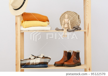 Wooden shelving with clothes, autumn season clothes Wooden shelving with clothes, autumn season clothes 95122570