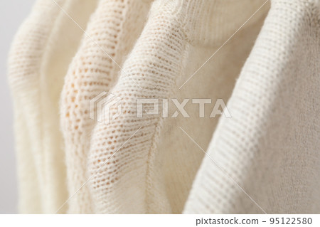 Sweaters hang on hangers, close up and selective focus Sweaters hang on hangers, close up and selective focus 95122580