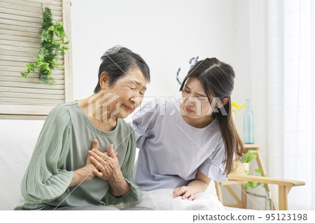 Elderly woman with chest pain in the living room Elderly woman with chest pain in the living room 95123198