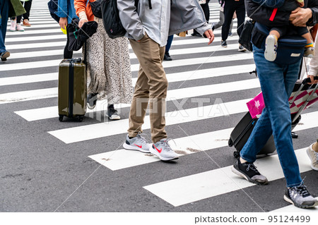people crossing a pedestrian crossing 95124499