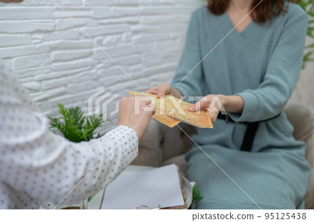 Psychologist uses metaphorical associative cards in a session with a patient. Close-up of female hands. Psychologist uses metaphorical associative cards in a session with a patient. Close-up of female hands. 95125438