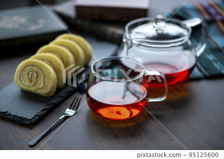 玻璃杯中的茶和石板上的捲餅 95125600