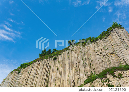 top of columnar volcanic basalt cliff against the background of the sky with clouds top of columnar volcanic basalt cliff against the background of the sky with clouds 95125890
