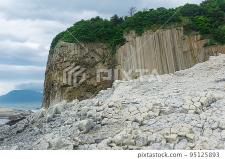 Columnar basalt rock, Cape Stolbchaty on Kunashir Island, in the foreground bases of lava basalt columns form a kind of pavement Columnar basalt rock, Cape Stolbchaty on Kunashir Island, in the foreground bases of lava basalt columns form a kind of pavement 95125893