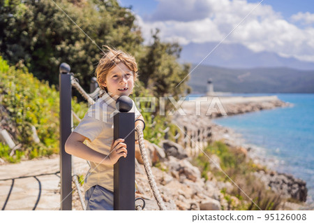 Boy tourist enjoying the views of Architecture and luxury yachts in Lustica Bay, Montenegro. Travel around Montenegro concept. Go Everywhere Boy tourist enjoying the views of Architecture and luxury yachts in Lustica Bay, Montenegro. Travel around Montenegro concept. Go Everywhere 95126008
