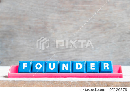 Tile alphabet letter with word founder in red color rack on wood background Tile alphabet letter with word founder in red color rack on wood background 95126278