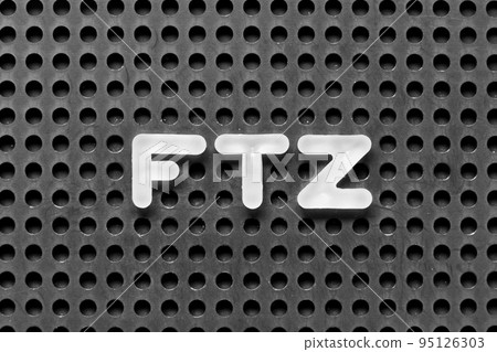 White alphabet letter in word FTZ (Abbreviation of Free trade zone) on black pegboard background 95126303