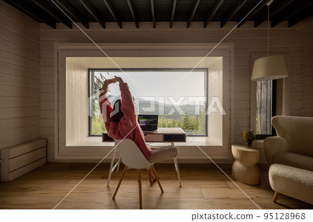 Woman works on laptop remotely in house on nature 95128968