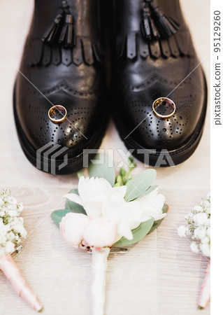 Set of mans fashion shoes with two golden wedding rings and beautiful wedding bouquet with different flowers, roses Set of mans fashion shoes with two golden wedding rings and beautiful wedding bouquet with different flowers, roses 95129260