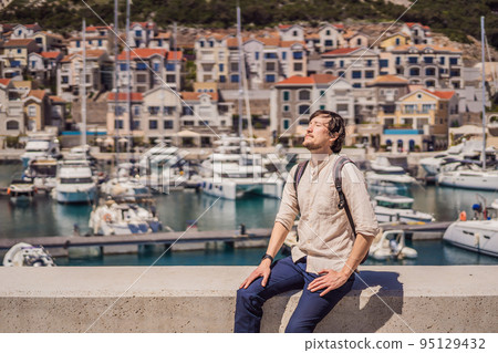 Man tourist enjoying the views of Architecture and luxury yachts in Lustica Bay, Montenegro. Travel around Montenegro concept. Go Everywhere 95129432