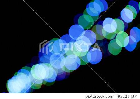 Abstract magic background with bokeh effect. Three blue garlands, defocused bokeh lights on an isolated black background. Overlay for your design. High quality photo 95129437