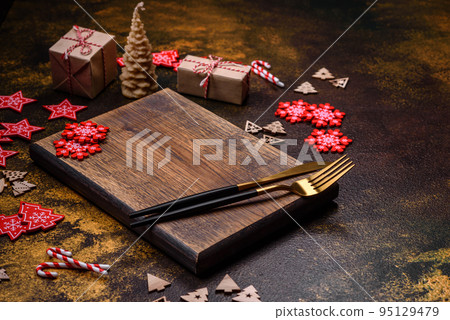 Beautiful gingerbread on a brown ceramic plate with Christmas tree decorations 95129479