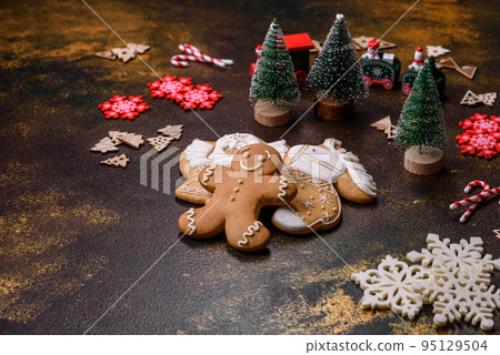 Beautiful gingerbread on a brown ceramic plate with Christmas tree decorations 95129504