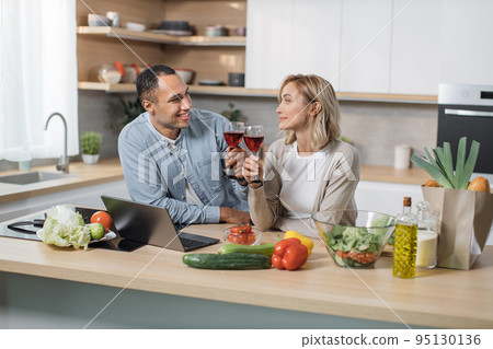 Joyful family cooking dinner at modern light home. Joyful family cooking dinner at modern light home. 95130136