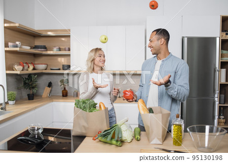 Arab guy throwing tomatoes for fun in kitchen. Arab guy throwing tomatoes for fun in kitchen. 95130198