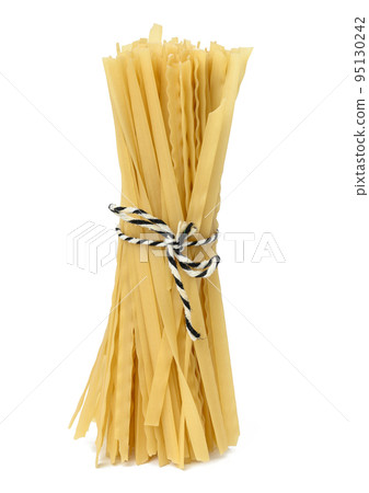 Raw long pasta tied with a rope on a white isolated background Raw long pasta tied with a rope on a white isolated background 95130242