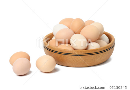 Raw brown and white chicken eggs in a wooden plate 95130245