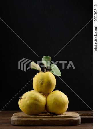 Ripe yellow quince on a wooden board Ripe yellow quince on a wooden board 95130246