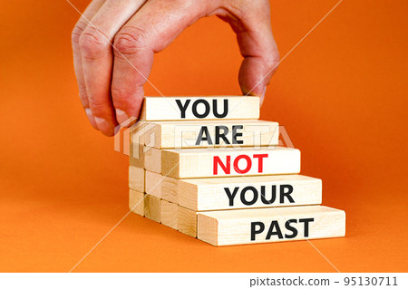 You are not your past symbol. Concept words You are not your past on wooden blocks. Businessman hand. Beautiful orange table orange background. Business and you are not your past concept. Copy space. 95130711