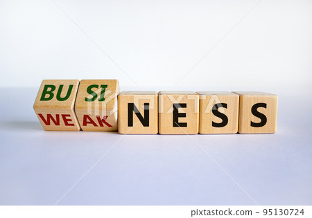 Business or weakness symbol. Turned wooden cubes and changed the word 'weakness' to 'business'. Beautiful white background, copy space. Business or weakness concept. Business or weakness symbol. Turned wooden cubes and changed the word 'weakness' to 'business'. Beautiful white background, copy space. Business or weakness concept. 95130724