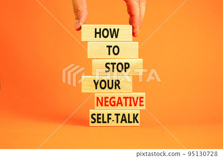 Stop negative self-talk symbol. Concept words Stop to flip your negative self-talk typed on blocks. Psychologist hand. Beautiful orange background. Psychological negative self-talk concept. Copy space 95130728