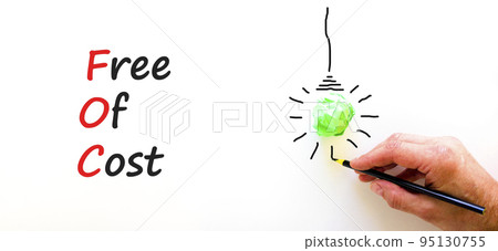 FOC free of cost symbol. Concept words FOC free of cost on white paper on a beautiful white background. Green light bulb icon. Businessman hand. Business and FOC free of cost concept. Copy space. 95130755