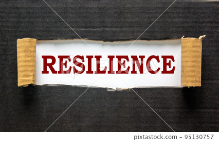 The text 'resilience' appearing behind torn black paper. The text 'resilience' appearing behind torn black paper. 95130757